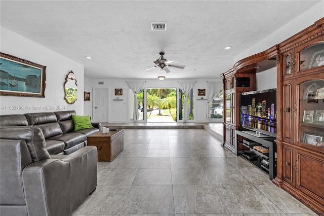 living room featuring ceiling fan and light tile flooring