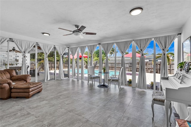 sunroom / solarium featuring plenty of natural light and ceiling fan