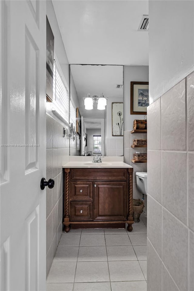 bathroom featuring tile walls, tile floors, toilet, and vanity