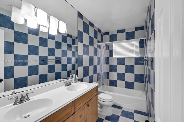 full bathroom with tile walls, toilet, dual bowl vanity, tiled shower / bath, and tile flooring