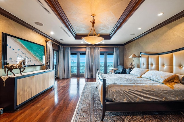 bedroom with a tray ceiling, dark wood-type flooring, and crown molding