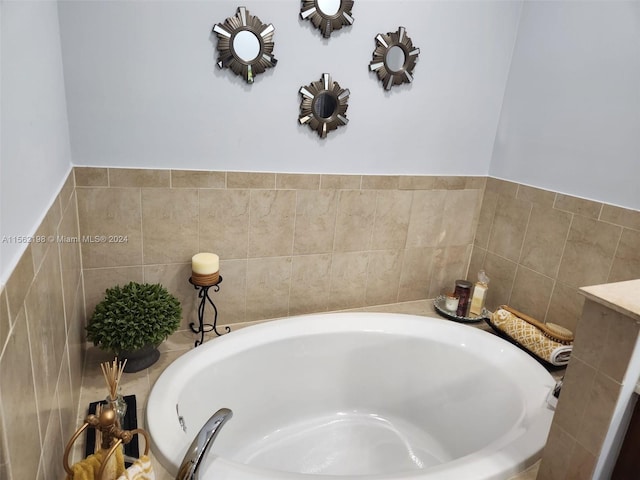 bathroom with a tub and tile walls