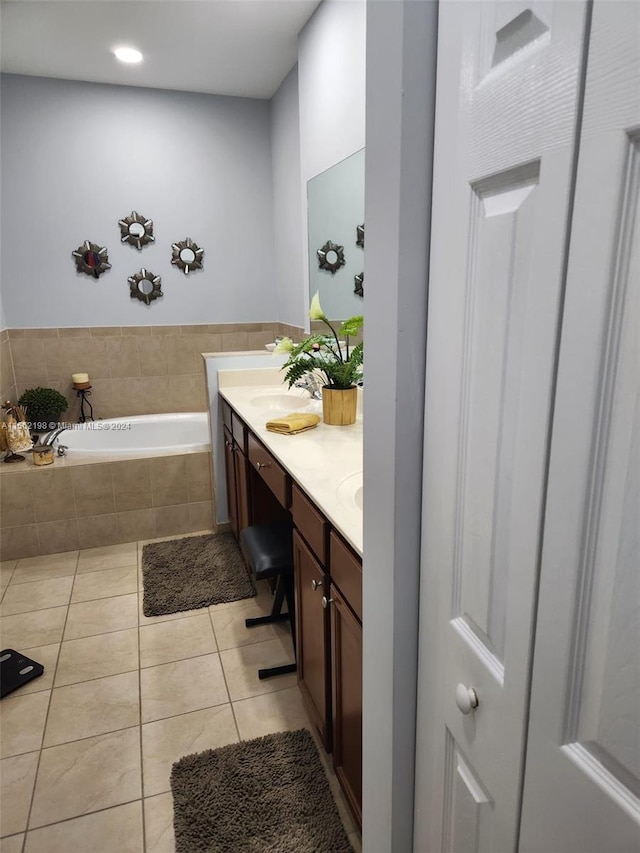 bathroom featuring tiled bath, oversized vanity, dual sinks, and tile flooring