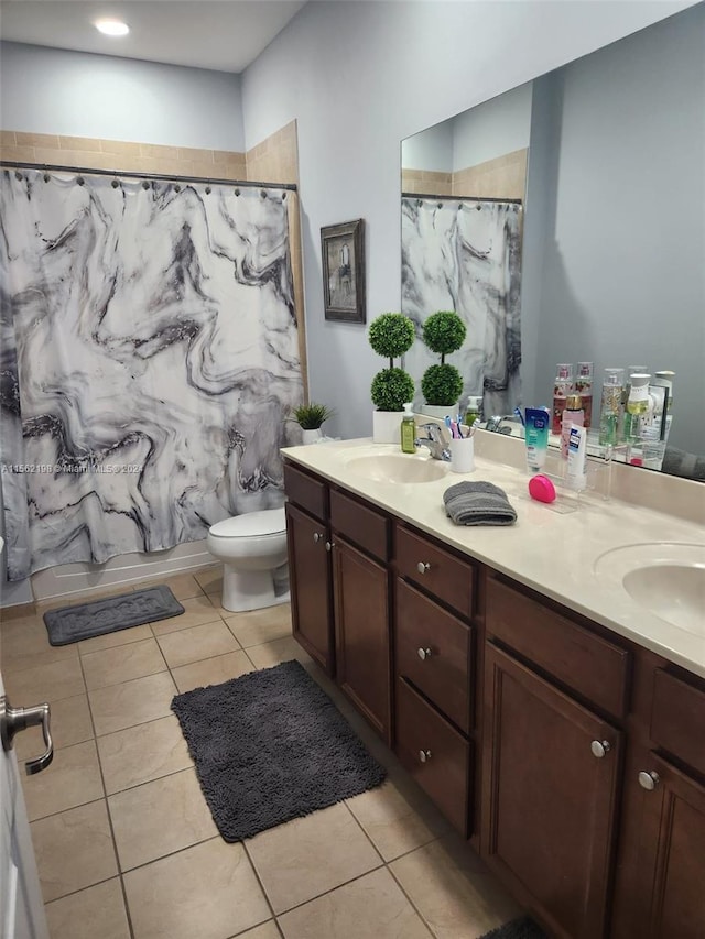 bathroom featuring double sink vanity, tile floors, and toilet