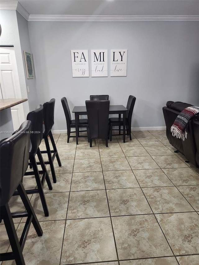 dining area with light tile flooring and ornamental molding