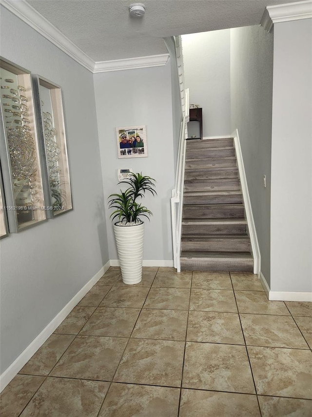 staircase featuring crown molding, a textured ceiling, and light tile floors