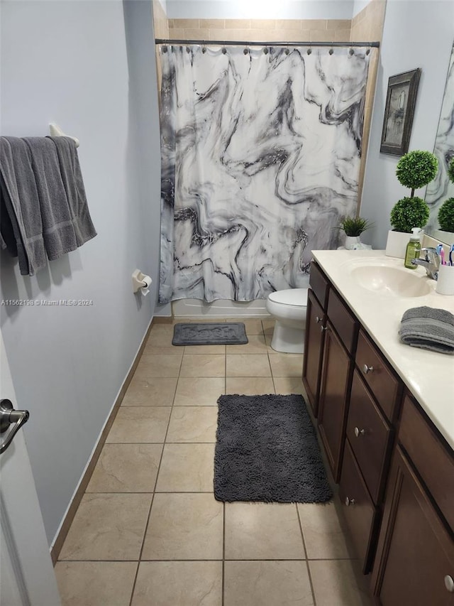 bathroom featuring toilet, tile floors, and vanity