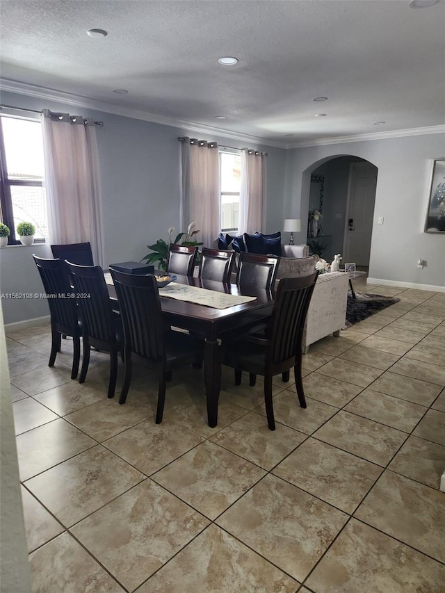 tiled dining space with crown molding and a textured ceiling