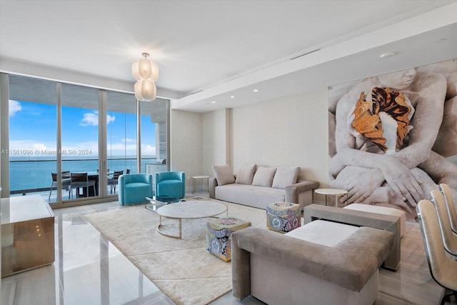 living room featuring a water view, a wall of windows, and light tile floors