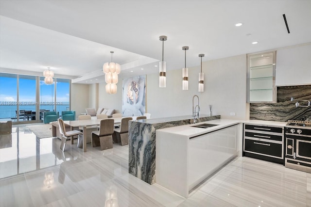 kitchen with sink, floor to ceiling windows, hanging light fixtures, light tile flooring, and tasteful backsplash