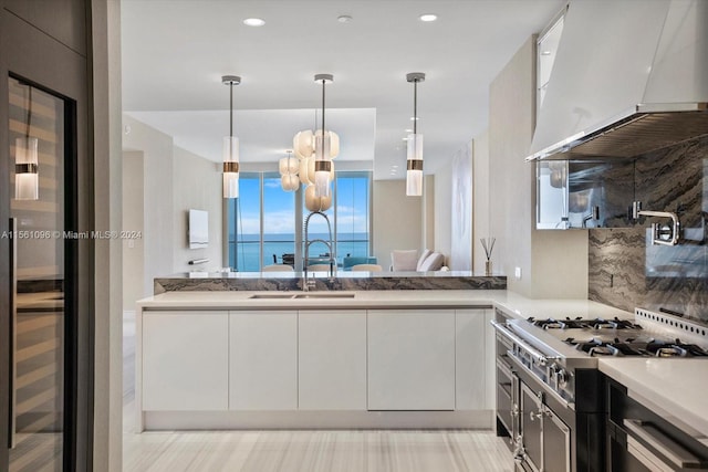 kitchen featuring pendant lighting, white cabinets, sink, and custom exhaust hood