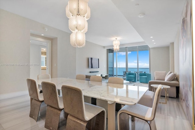 dining room featuring a water view, expansive windows, and light wood-type flooring