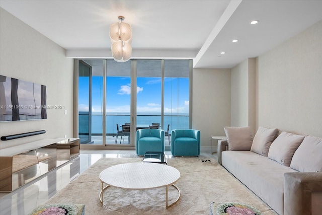 living room with expansive windows, light tile floors, and a water view