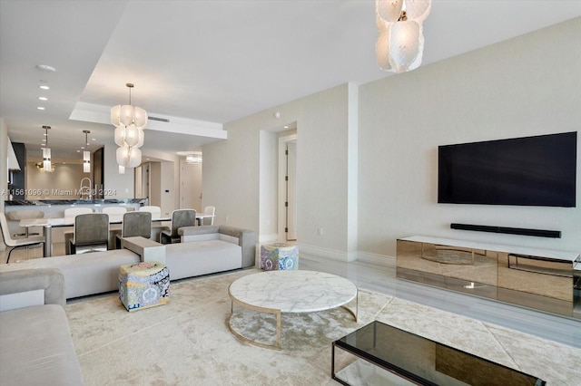 living room with a tray ceiling and sink