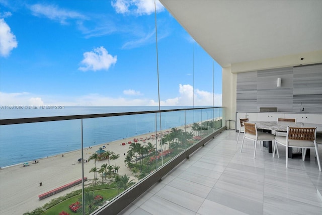 balcony with a water view and a view of the beach