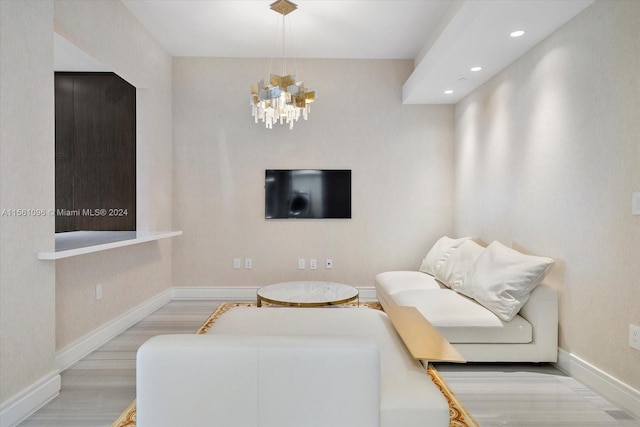 living room with light hardwood / wood-style floors and a chandelier