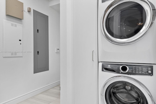 laundry room featuring light hardwood / wood-style floors and stacked washer and dryer