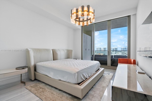 bedroom with a notable chandelier, expansive windows, access to outside, and light hardwood / wood-style flooring