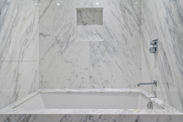 bathroom with a relaxing tiled bath