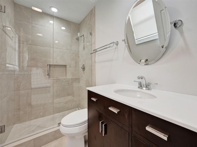 bathroom featuring tile floors, toilet, large vanity, and walk in shower