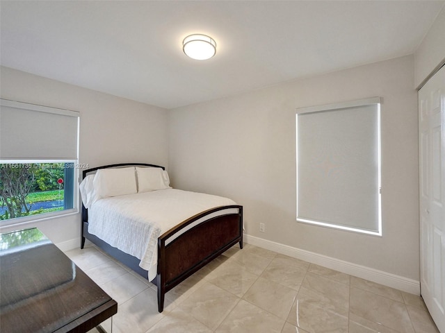 bedroom with light tile flooring and a closet