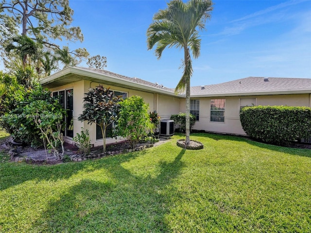 back of house with a lawn and central AC