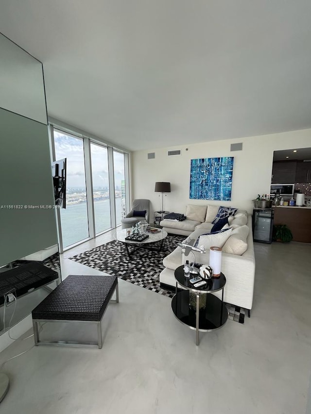 living room featuring a wall of windows and a water view