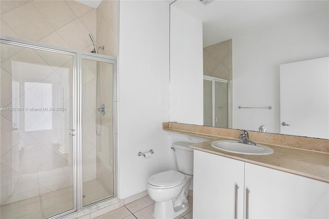 bathroom featuring an enclosed shower, tile flooring, oversized vanity, and toilet