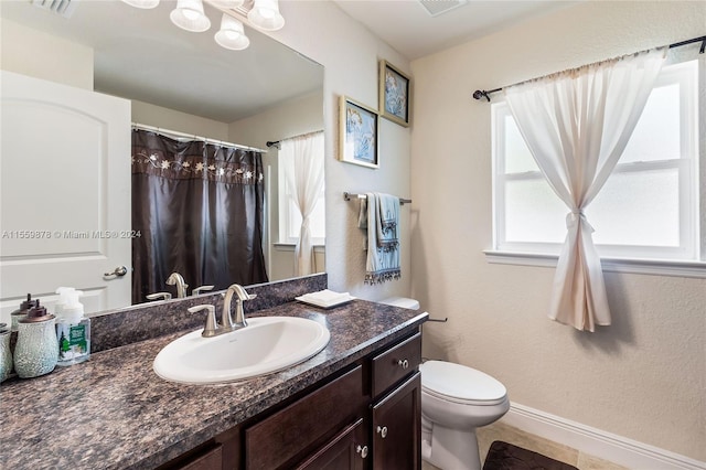 bathroom featuring tile flooring, toilet, large vanity, and a chandelier