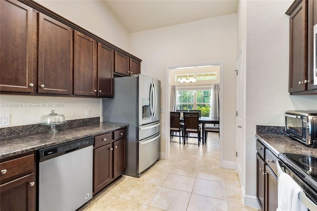 kitchen with an inviting chandelier, dark brown cabinets, light tile floors, and stainless steel appliances