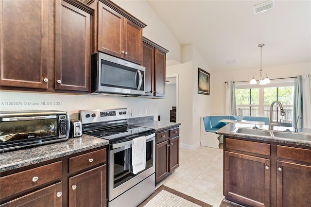 kitchen featuring stainless steel appliances, a notable chandelier, sink, light tile flooring, and vaulted ceiling