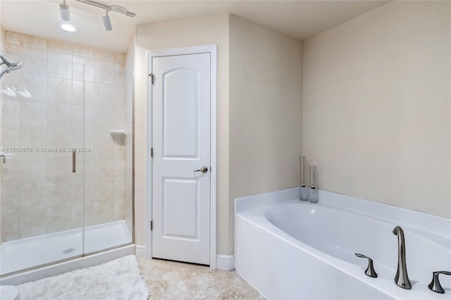 bathroom with shower with separate bathtub and tile flooring