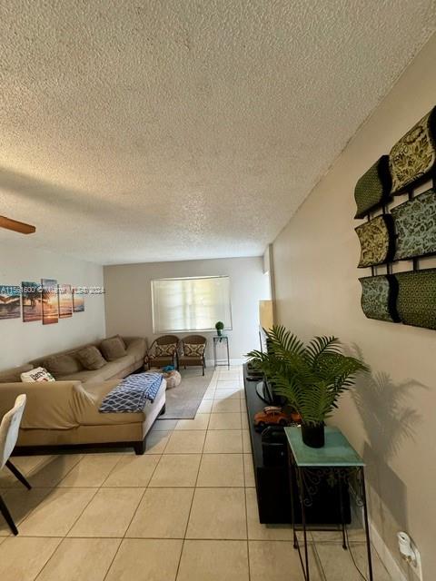 tiled bedroom featuring ceiling fan and a textured ceiling