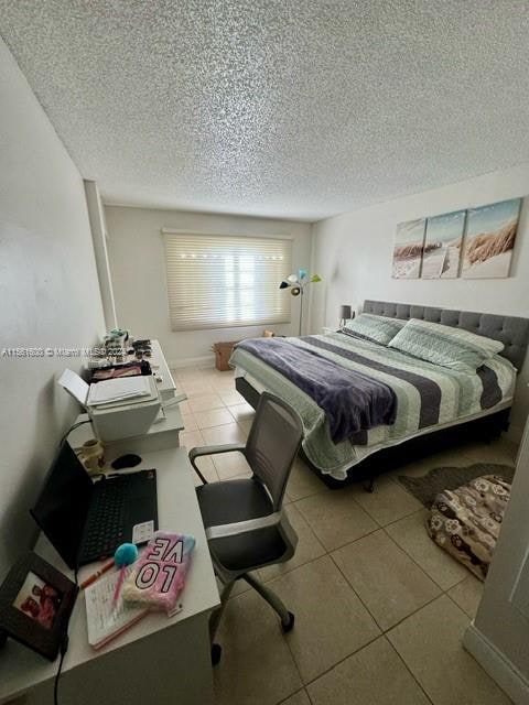 tiled bedroom featuring a textured ceiling