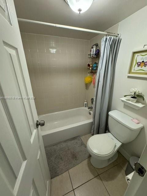 bathroom with toilet, shower / bath combo, and tile floors