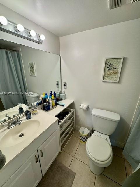 bathroom featuring toilet, large vanity, and tile flooring