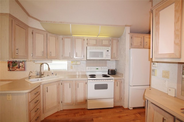 kitchen with light brown cabinetry, sink, white appliances, and light hardwood / wood-style floors