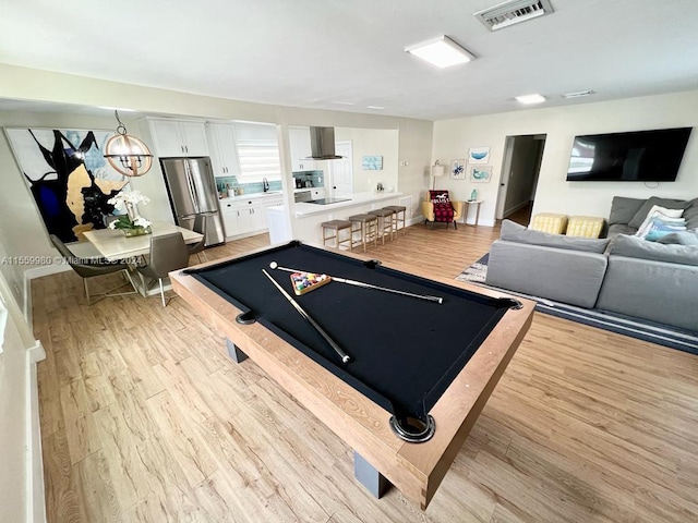 playroom with a chandelier, billiards, light wood-type flooring, and sink