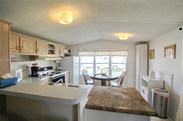 kitchen with light brown cabinets, white appliances, a textured ceiling, and lofted ceiling