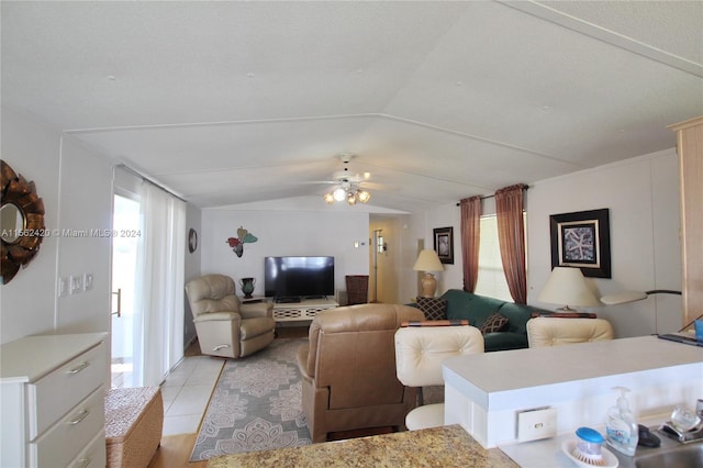 tiled living room with ceiling fan and lofted ceiling