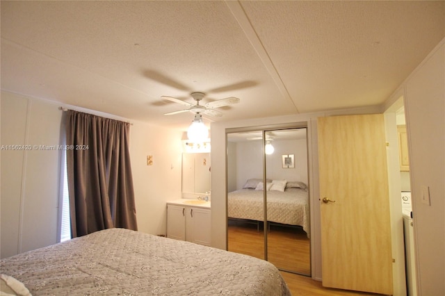 bedroom with light hardwood / wood-style flooring, ceiling fan, a textured ceiling, a closet, and sink