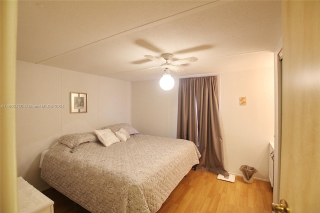 bedroom with light hardwood / wood-style floors and ceiling fan