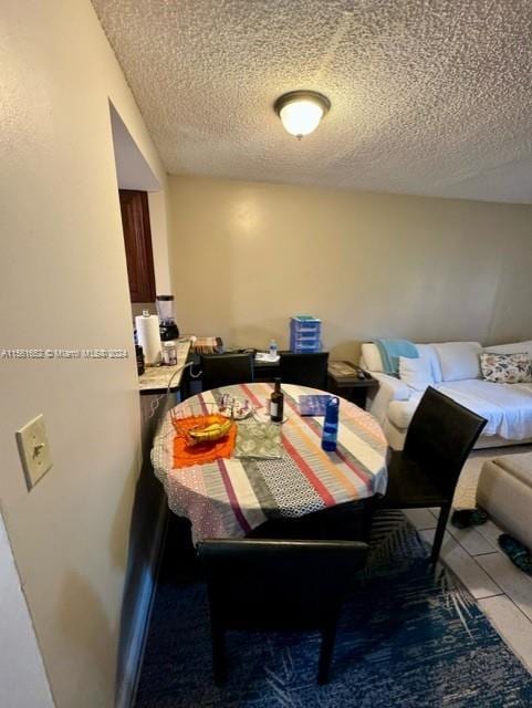 dining space with a textured ceiling and tile floors