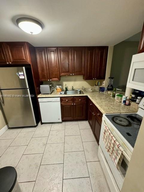 kitchen featuring light tile floors, white appliances, and sink