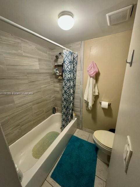 bathroom featuring toilet, shower / bath combo, and tile floors