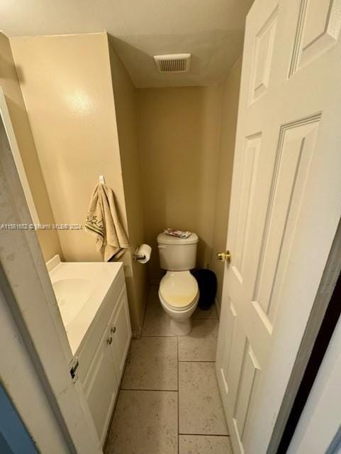 bathroom with tile floors, toilet, and vanity