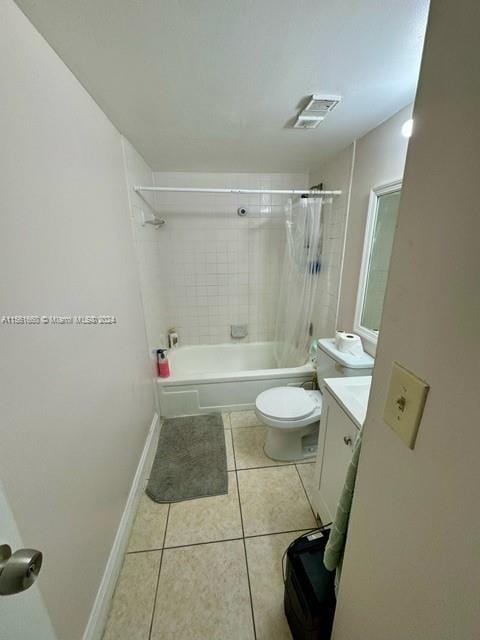 full bathroom with tile floors, tiled shower / bath combo, toilet, and vanity