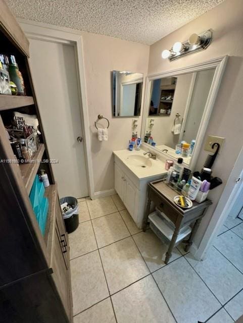 bathroom with large vanity, tile floors, and a textured ceiling