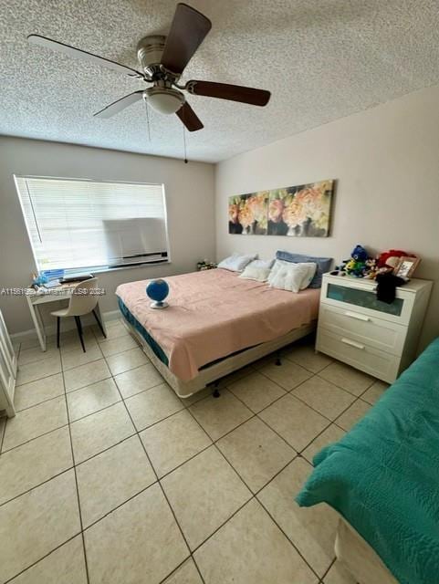 tiled bedroom featuring a textured ceiling and ceiling fan