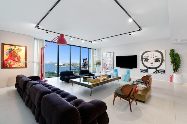 tiled living room with a water view, expansive windows, and track lighting